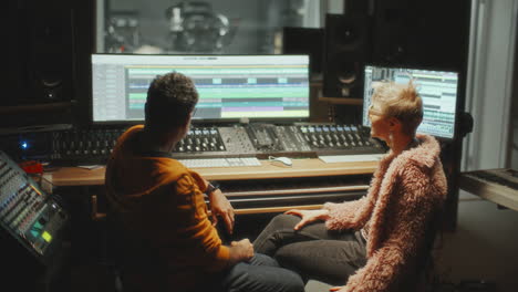 music producer and female singer collaborating in recording studio