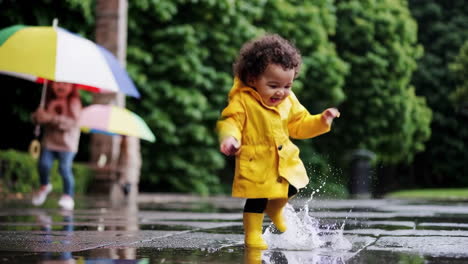 joyful toddler splashing in puddles on a rainy day