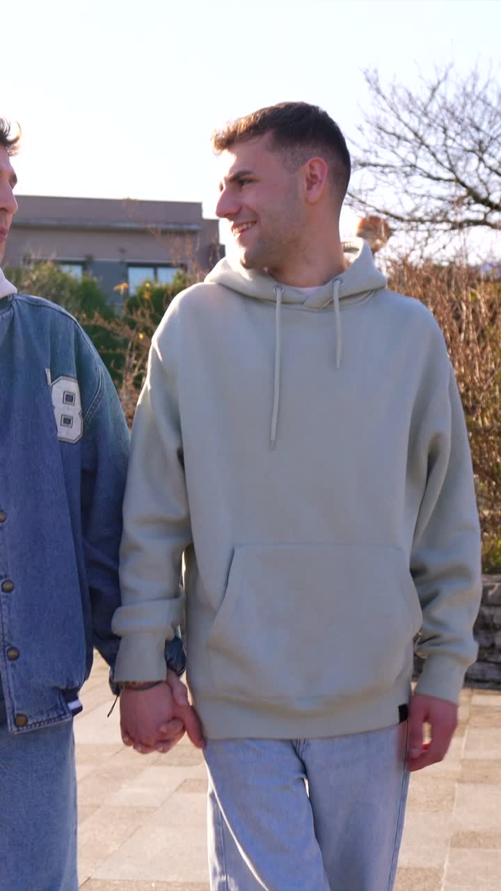 Two men holding hands outdoors