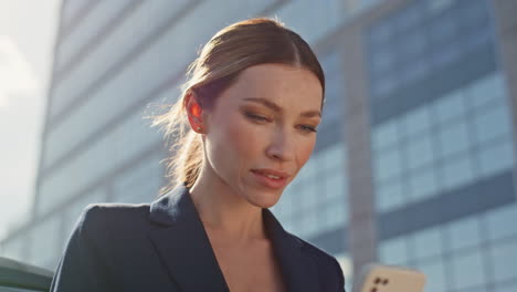 gorgeous lady typing cellphone on business district close up. woman messaging