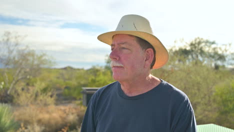 older single lonely man wearing fedora hat sits outdoor pensive lost in thought