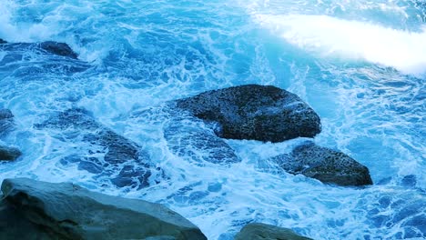 Abstract-Of-White-Foamy-Waves-Crashing-Over-Rocks-During-Summer