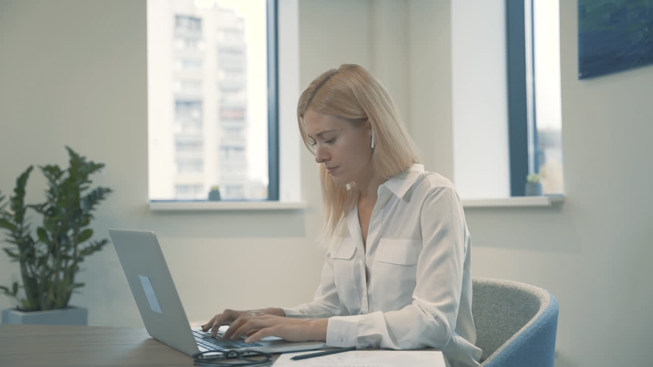 vista lateral del hombre que trabaja con pc y bebe café sentado en el escritorio en la oficina