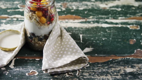 yogur con granadas y bayas doradas en frasco de vidrio 4k