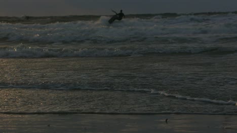 in rays of setting sun, kitesurfer enjoys freedom and excitement of kiteboarding, feeling rush of adrenaline with every movement