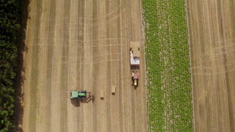 Modern-Tractor-Gathering-Square-Bales-From-The-Harvested-Farmland-In-Poland