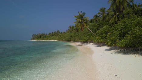 Drone-flying-over-the-Maldivian-coast-with-many-green-trees-against-a-stormy-sky