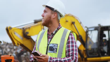 Male-worker-using-mobile-phone-in-the-junkyard-4k