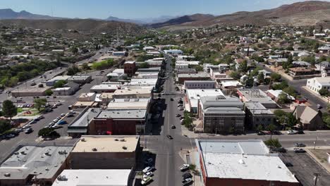 drone flying from south to north broad street in downtown globe arizona. cars driving down street, mountains in background on a bright summer day