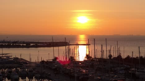 Drohne-Fliegt-über-Dem-Zentrum-Von-Flisvos-Im-Hafen-Von-Athen-An-Den-Ufern-Des-Ägäischen-Meeres-Bei-Sonnenuntergang-Mit-Segelboot,-Das-In-Der-Bucht-Festgemacht-Ist