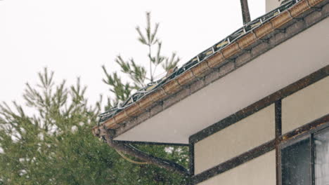 Escena-De-Copos-De-Nieve-Cayendo-Sobre-El-Techo-De-La-Casa-Durante-El-Día-En-Gifu,-Japón