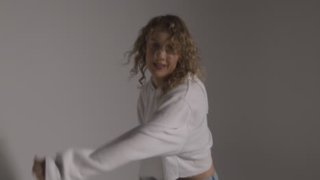 studio shot of young woman having fun dancing against grey background 4