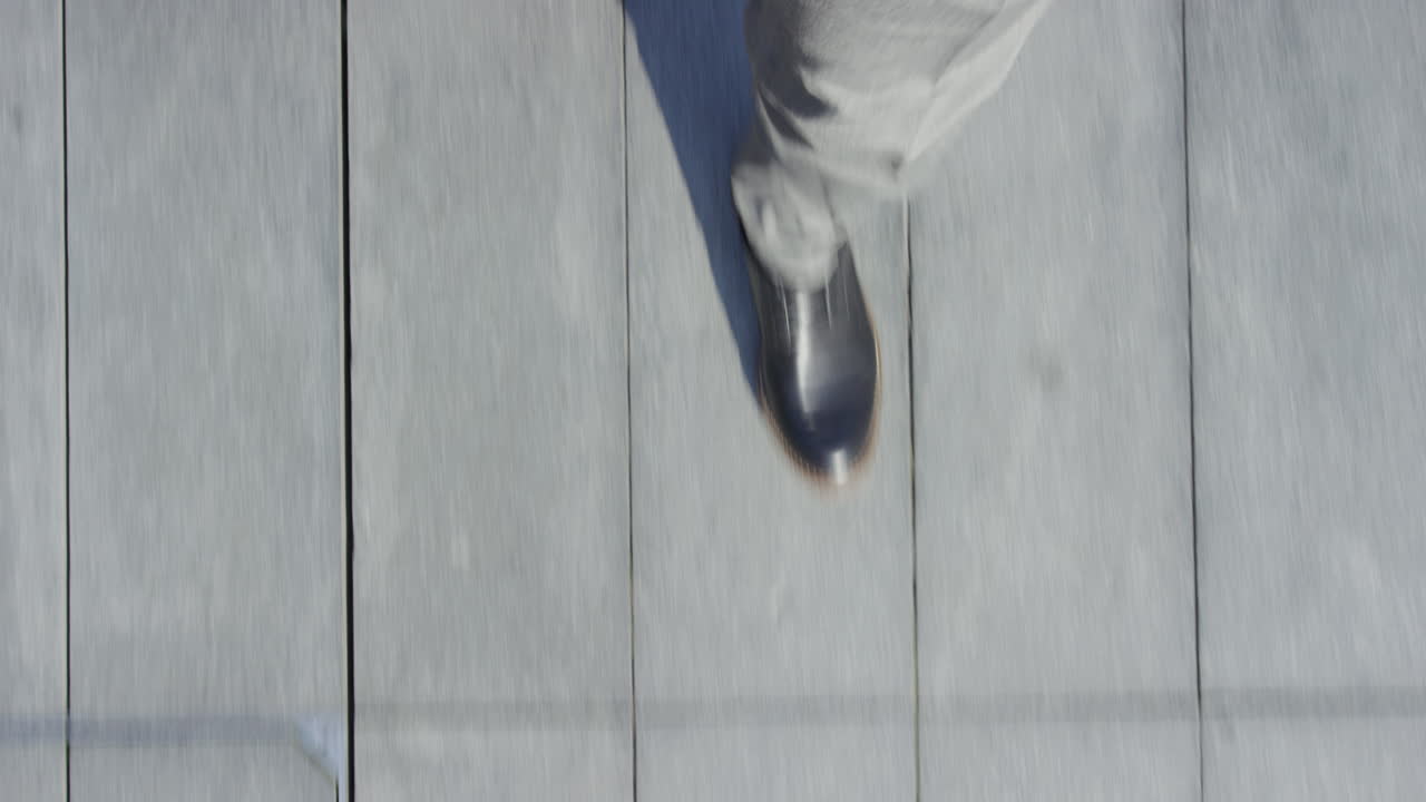 멋진 슈트 신발을 입고 보행로를  ⁇ 고 있는 사업가, 도시 탑 뷰에서 캐주얼하게 산책하고 있습니다.