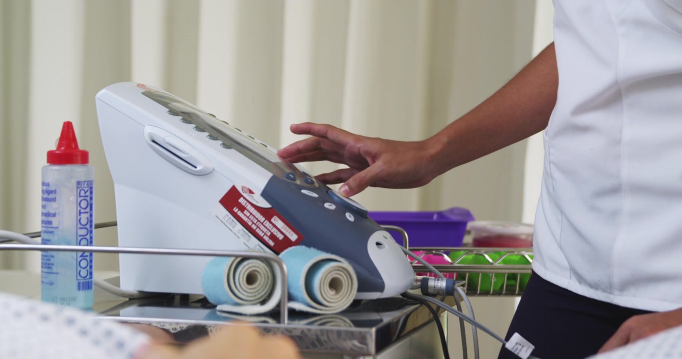 Therapist starts the electrode machine for therapy