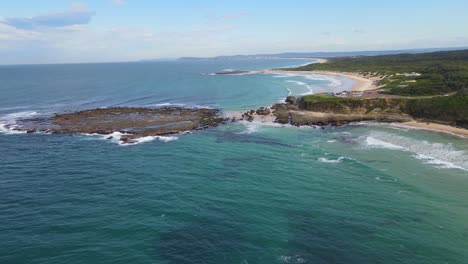 vista aérea de la punta de los soldados y la playa de los soldados junto al mar azul turquesa durante el día - playa de guijarros en norah head, nsw, australia