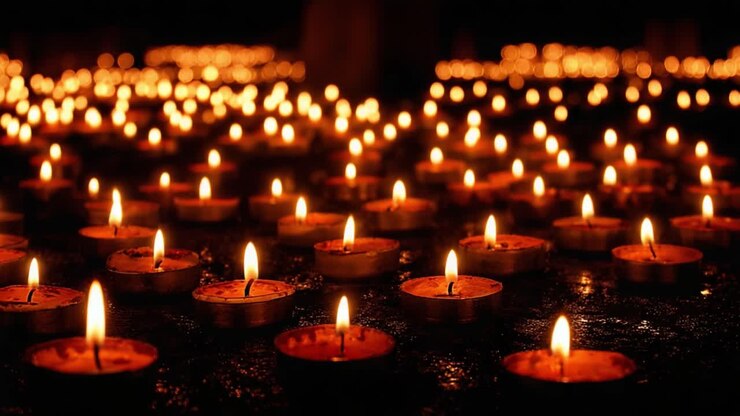 Una serena composizione di candele illuminate che proiettano una luce soffusa in uno spazio buio, creando un'atmosfera di pace e contemplazione