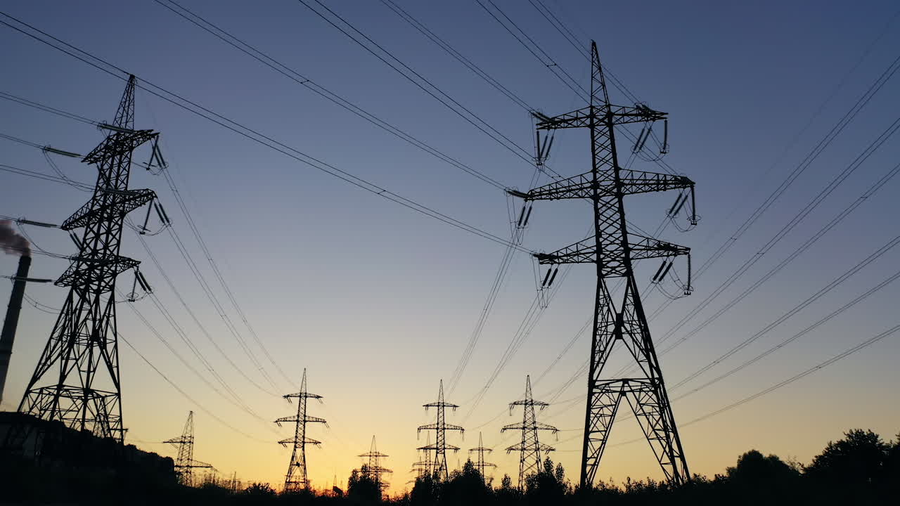 Electricity pylons in the evening.Silhouettes of high voltage power lines against the sunset sky. Transmission towers. Electric high voltage pylons in dusk.