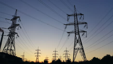 electricity pylons in the evening.silhouettes of high voltage power lines against the sunset sky. transmission towers. electric high voltage pylons in dusk.