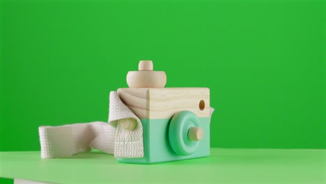 juguete de cámara fotográfica de madera de menta en fondo verde clave de croma reemplazo de fondo telón de fondo objeto en un bucle giratorio 3d