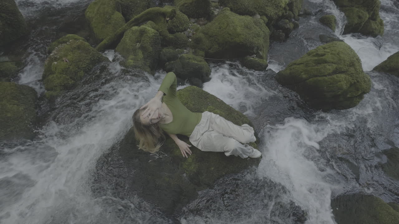 산의 하천 에서 휴식을 취하는 여자