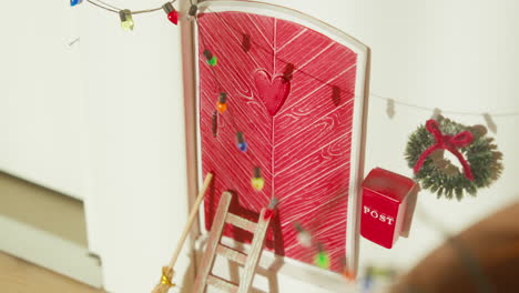 cute scandinavian elf door adorned for christmas with lights and wreath