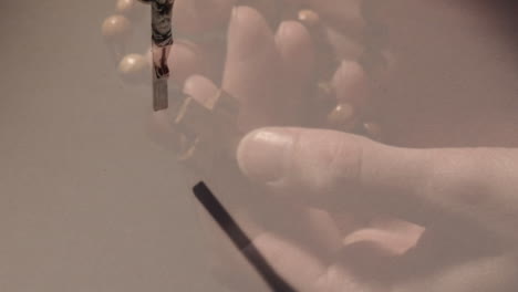 animación de una mujer caucásica orando con el rosario sobre la cruz