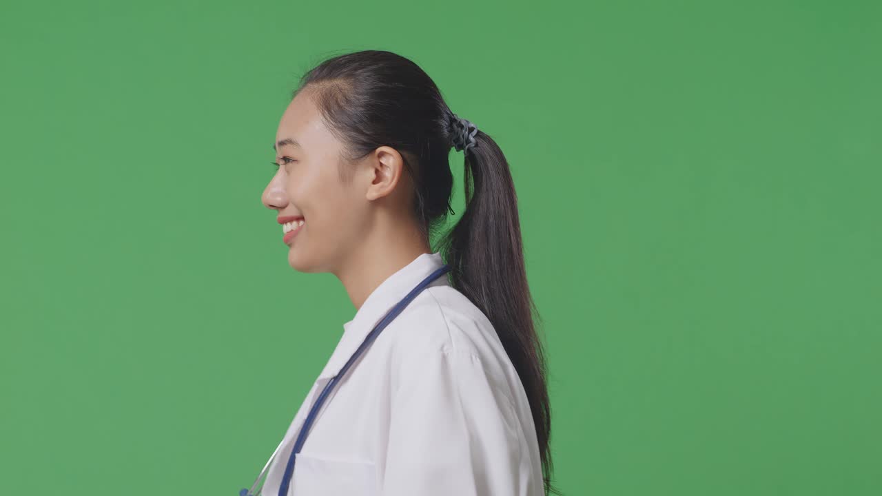 Close Up Of Side View Side View Asian Female Doctor With Stethoscope Walking On Green Screen Background In The Hospital