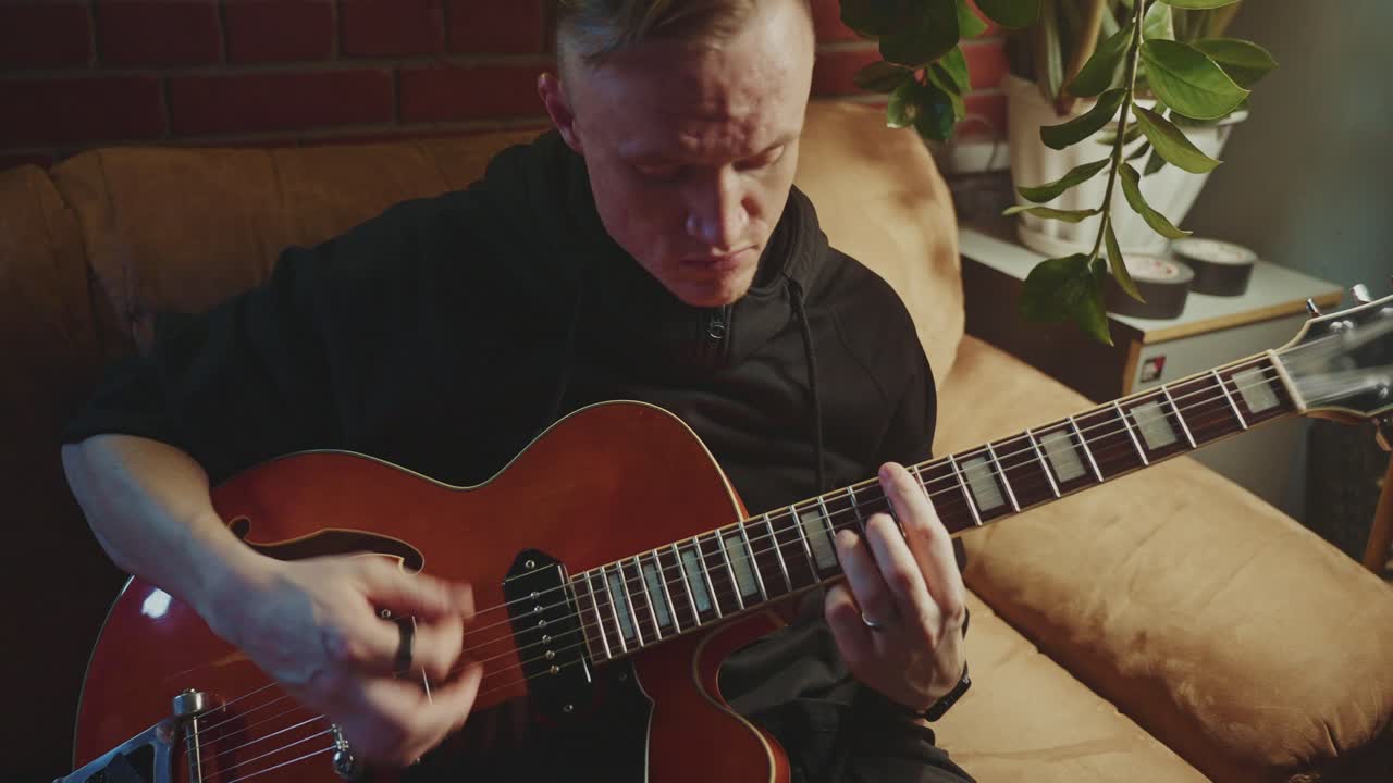 Man Playing Vintage Guitar at Home