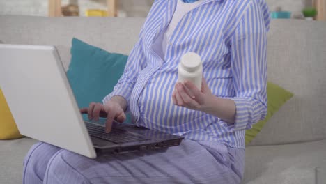 a unrecognizable young pregnant woman searches the internet for information about the drug