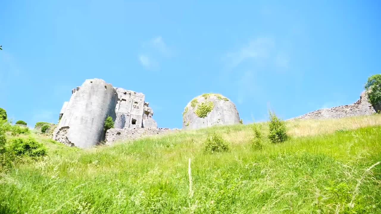 Looking up at and passing a tall, old castle on the road