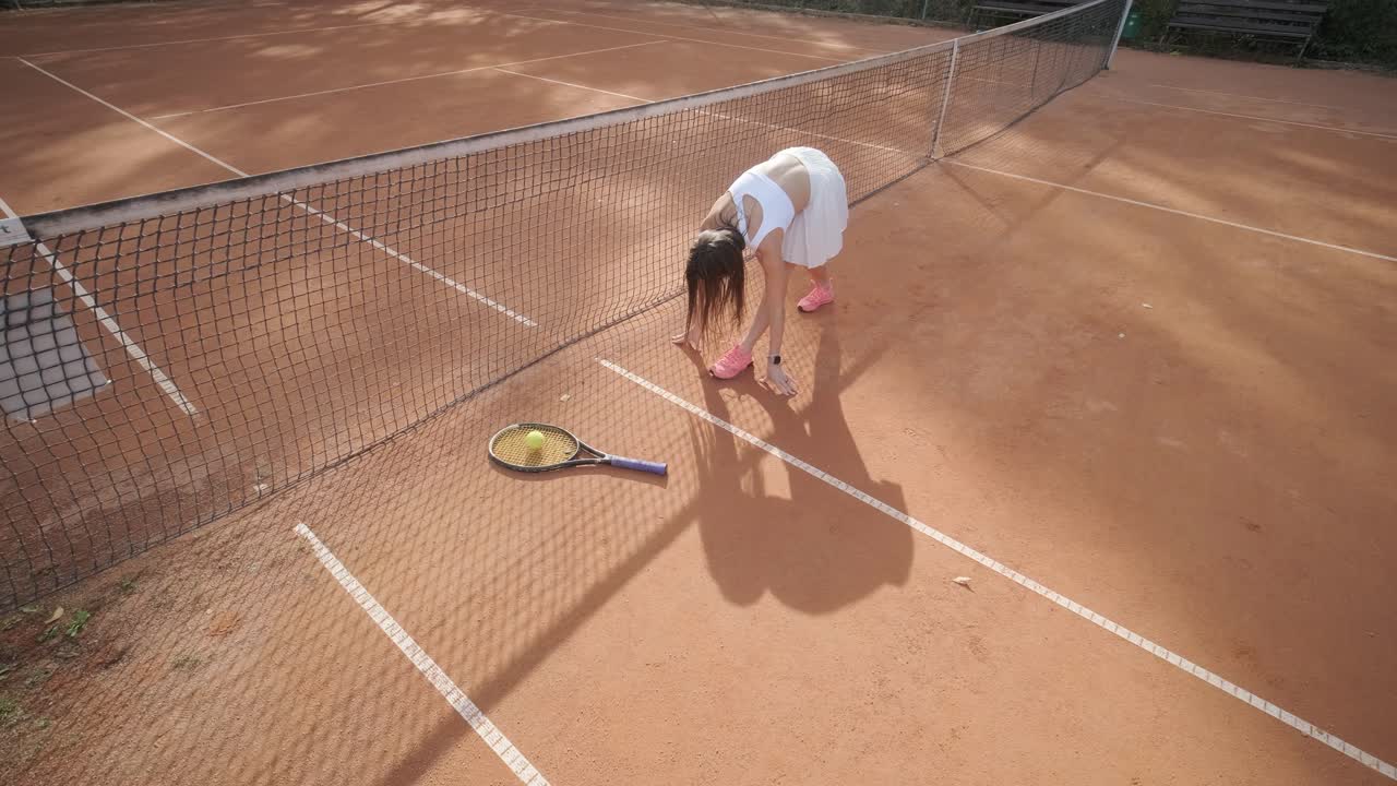 아름다운 테니스 소녀가 야외 코트에서 을 연습하고 있습니다.