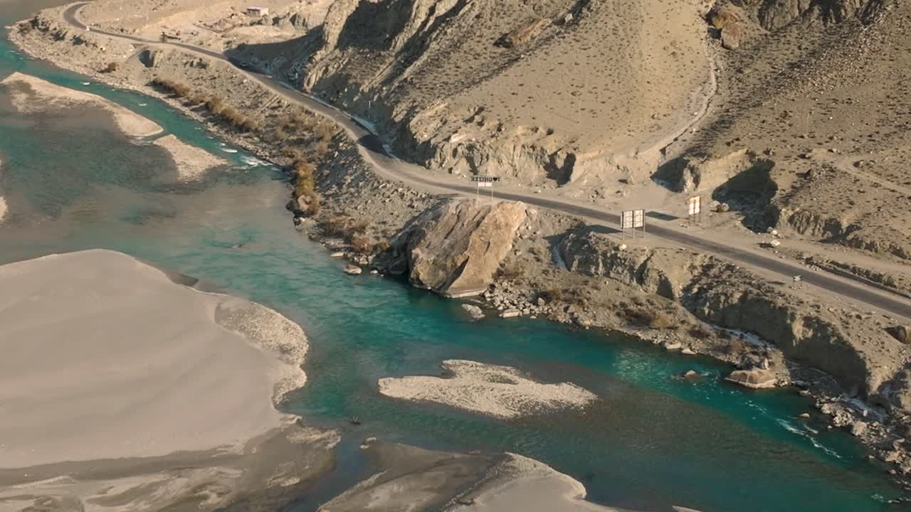 Fiume Ghizer color turchese che scorre attraverso la foresta a Gahkuch, circondato dalla catena montuosa dell'Hindu Kush