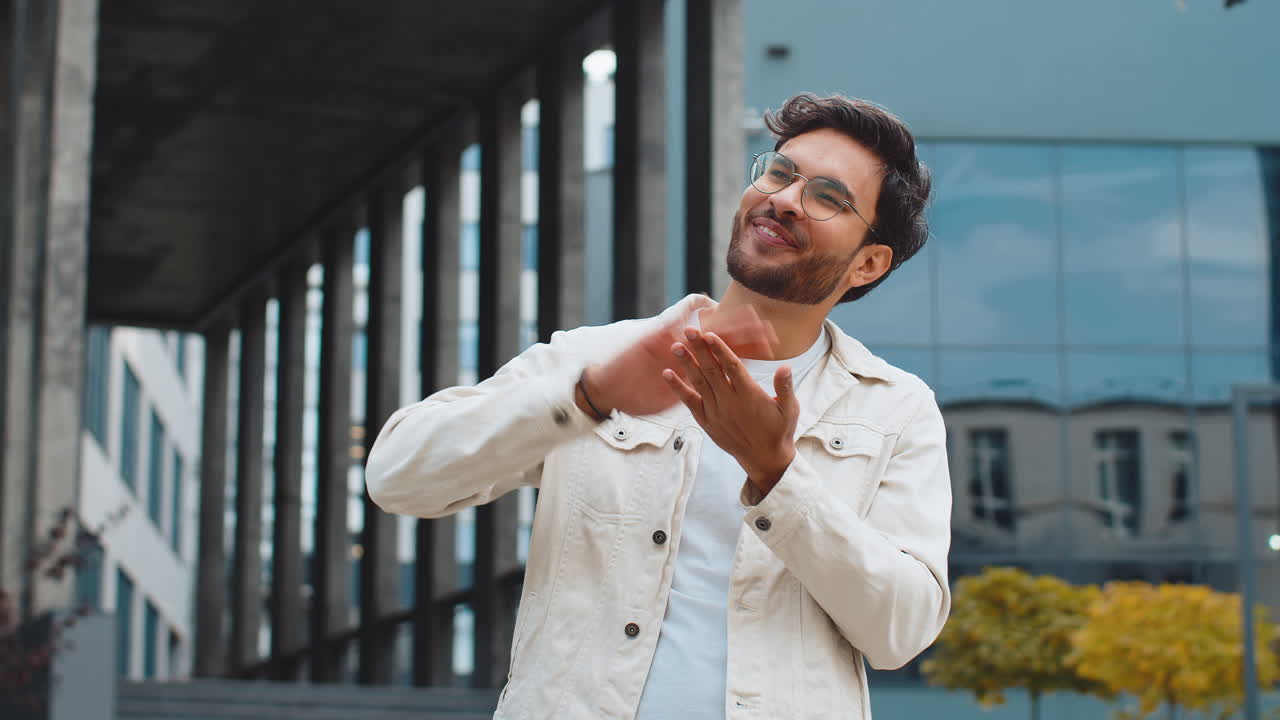 Cheerful rich indian man showing wasting throwing money win lottery share celebrate in city street
