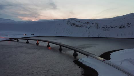 a supercar driving onto a bridge in a winter landscape during the winter