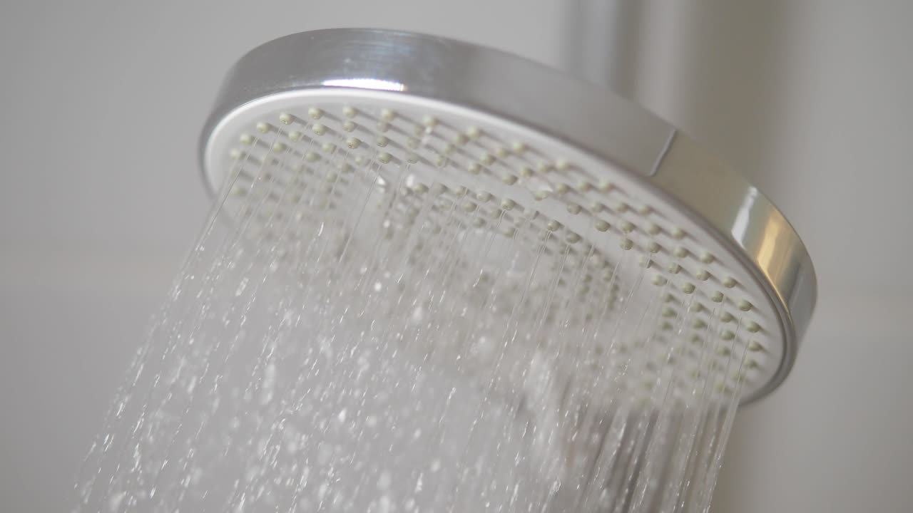 primer plano de un cabezal de ducha con agua fluyendo