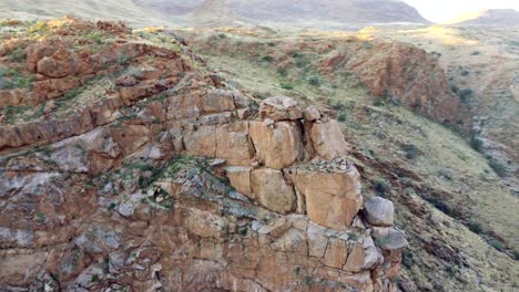 vista aérea cinematográfica rodeando rocas besándose en una exuberante garganta del desierto entre acantilados a la hora dorada en el parque riemvasmaak en sudáfrica cerca de namibia