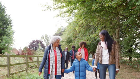 Familia-Multigeneracional-En-Otoño-Caminan-Juntos-En-El-Campo