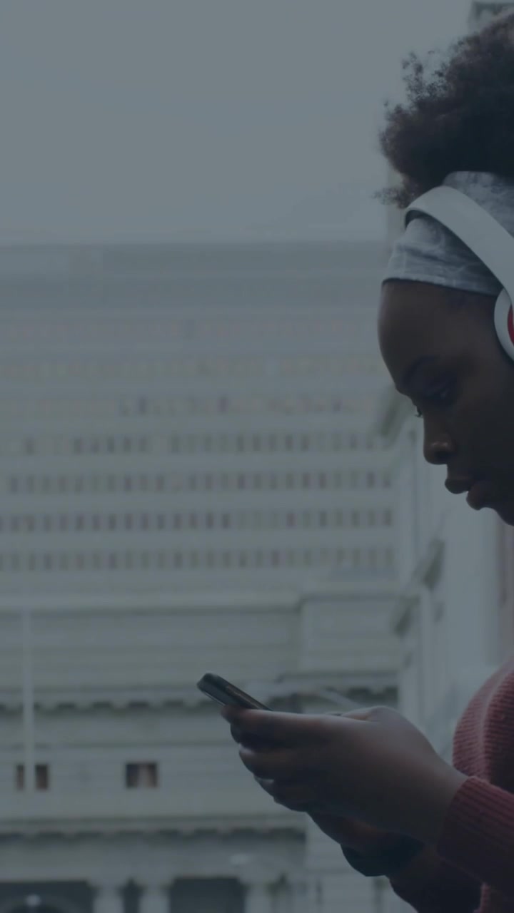 Processing data and loading animation over person with headphones holding smartphone