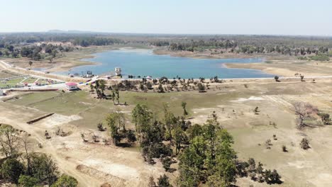 Backward-aerial-view-of-a-lake-during-afternoon-in-Jharkhand,-India