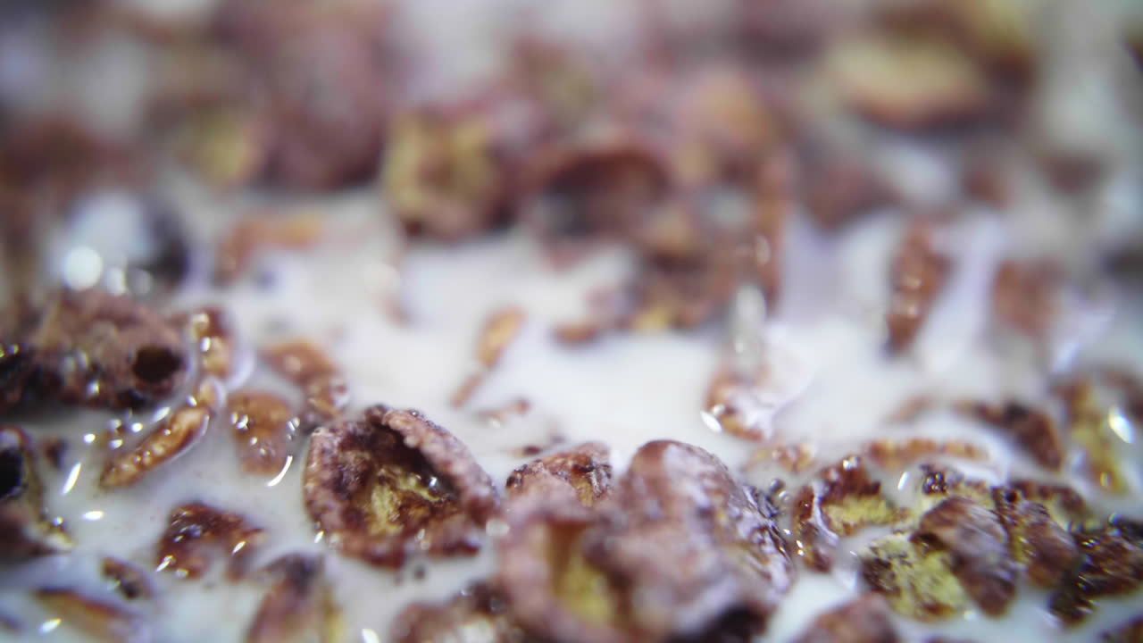 Primo piano di fiocchi di cereali al cioccolato nel latte con cucchiaio