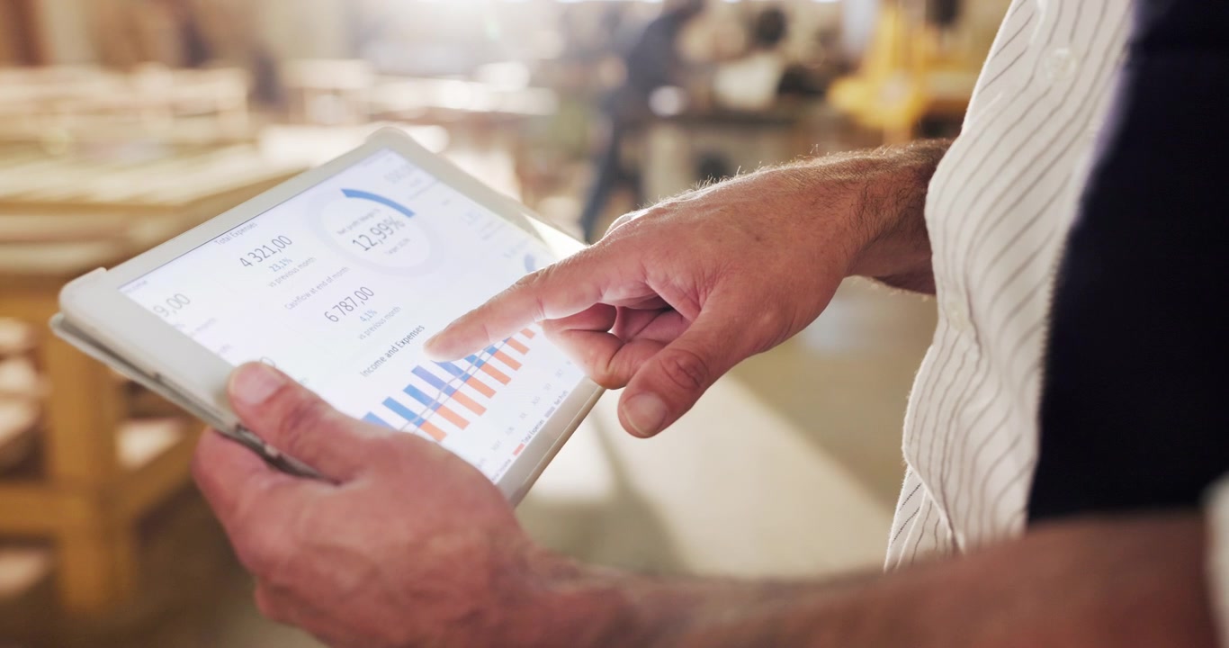Man Reviewing Business Data on Tablet in Workshop