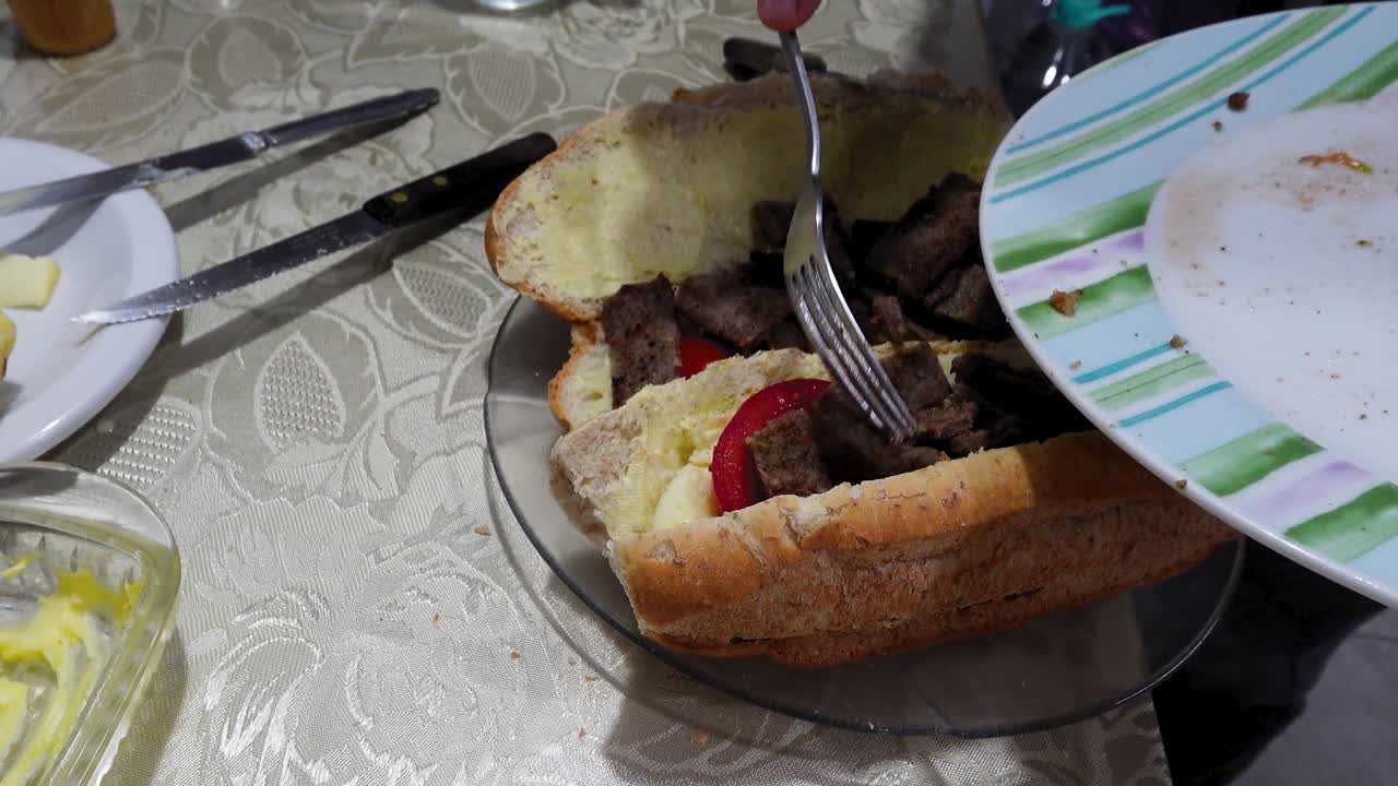 Man Adding Roast Beef to Deli Sandwich