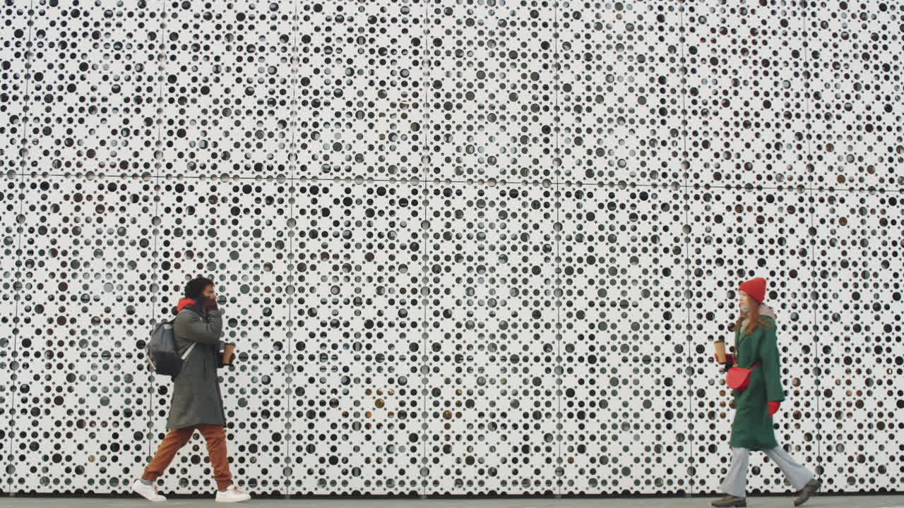 Two People Walking Along a Modern Building