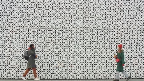 two people walking along a modern building