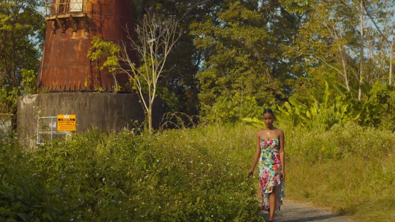 молодая сексуальная девушка гуляет по цветам у основания заброшенной военной станции радиолокационного слежения