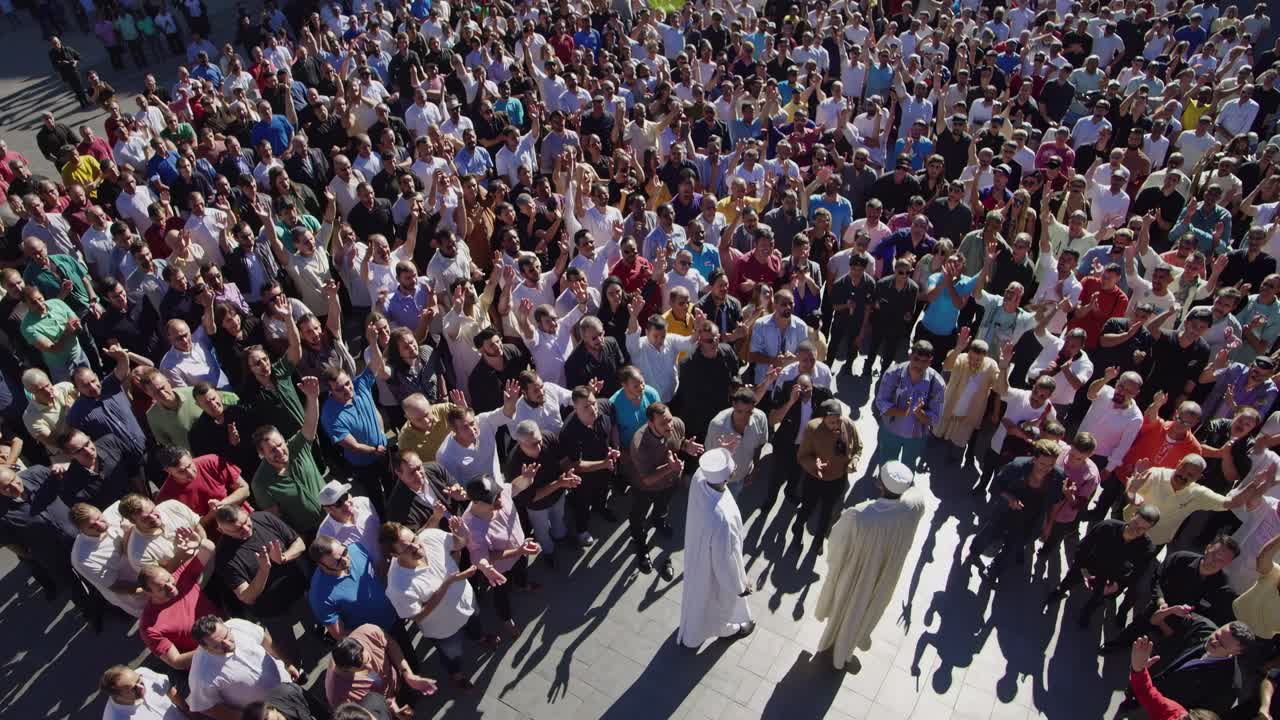 High-angle video shot of a large crowd gathered outdoors, showcasing diverse people in a lively