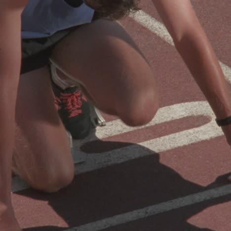 a runner kneels at the starting point then starts to race