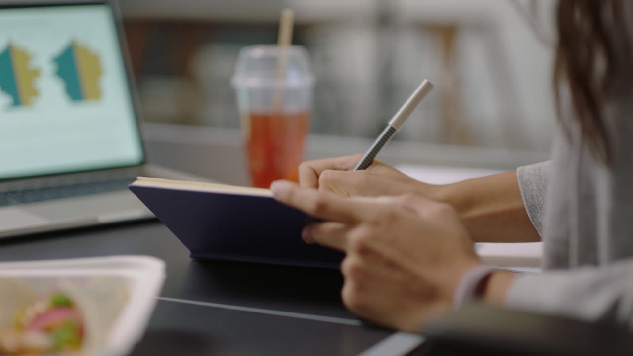 young business woman hands writing notes enjoying study using laptop computer viewing graph research data on screen working on project brainstorming ideas close up