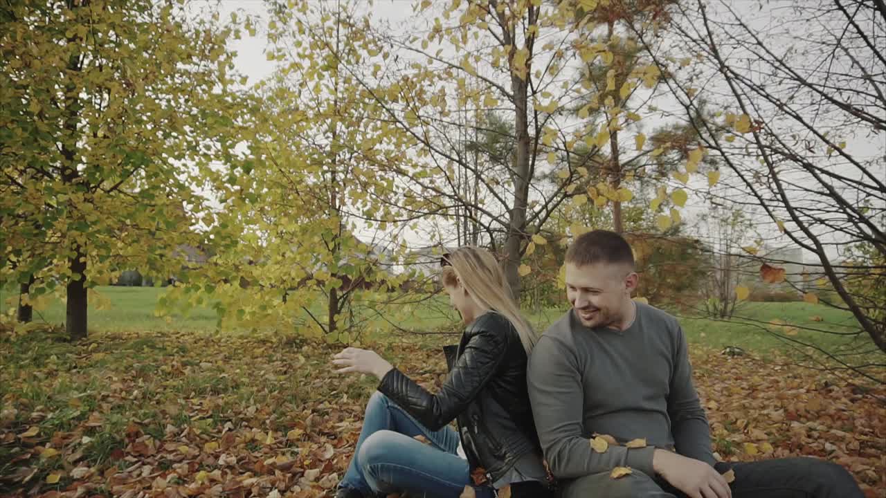 Couple enjoying autumn leaves in a park