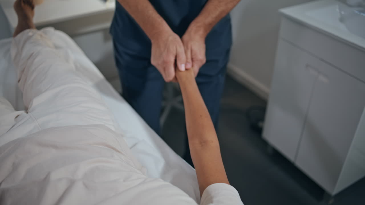 Primo piano di osteopata che tratta la mano durante una sessione di terapia. Fisioterapista esamina il braccio.